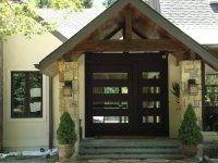 Modern pivot door with an ebony finish on Sapele with clear glass.